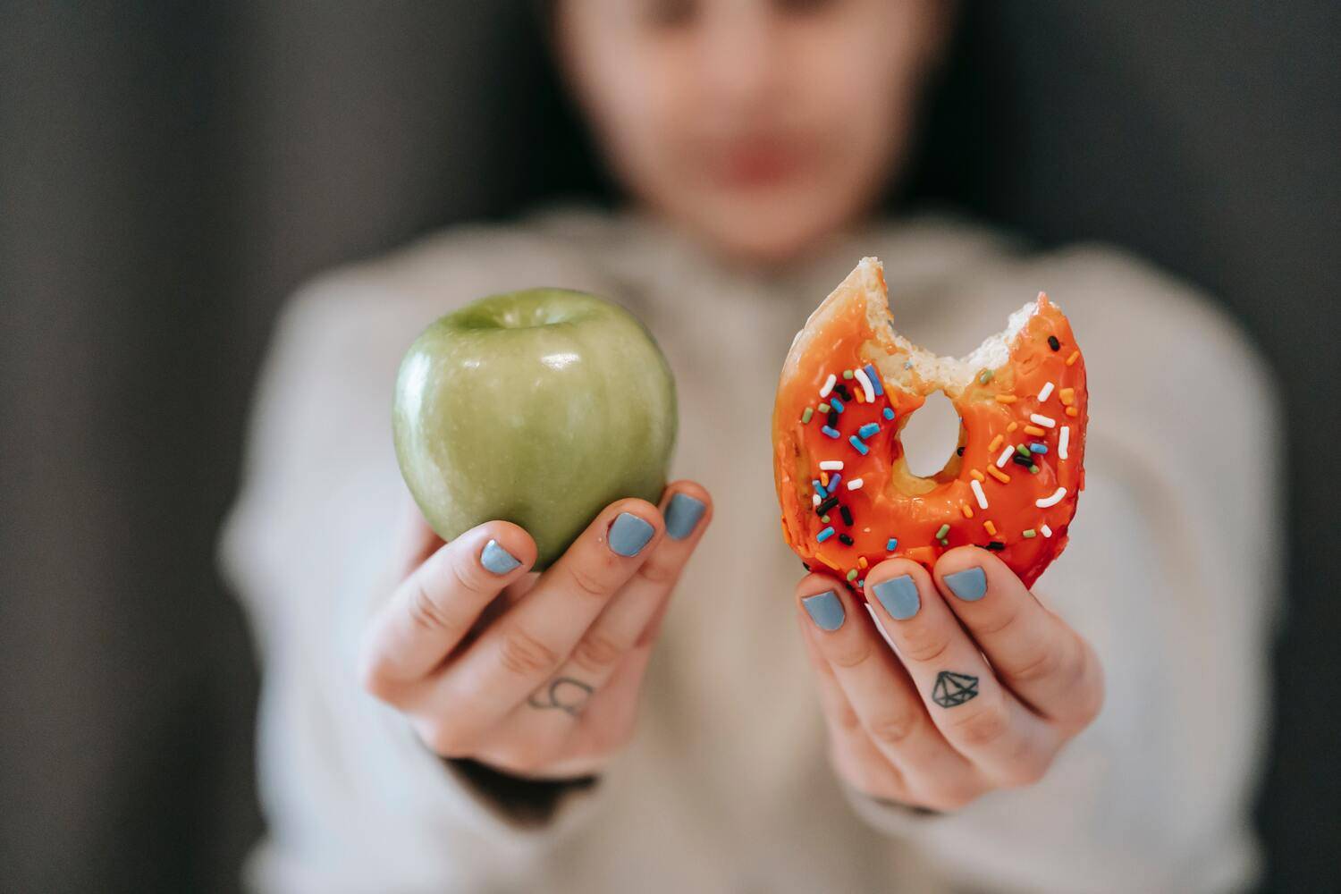 Ragazza indecisa se mangiare una mela o una ciambella di rimedi cerca rimedi efficaci per combattere la fame nervosa