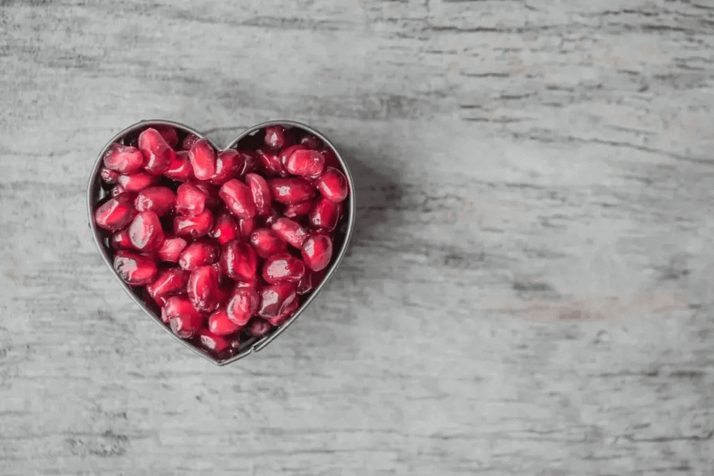 Porzione abbondante di semi di melograno in teglia a forma di cuore per uno stile di vita corretto